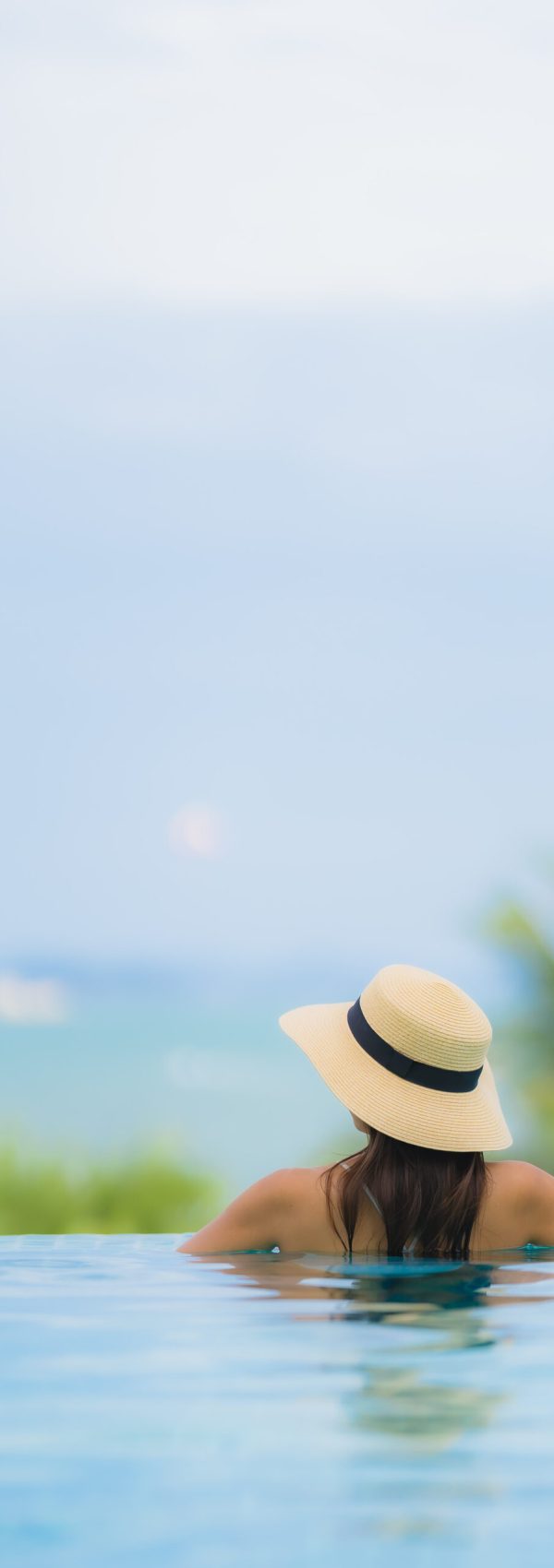 Portrait young asian woman happy smile relax around swimming pool in hotel resort for travel in holiday vacation concept