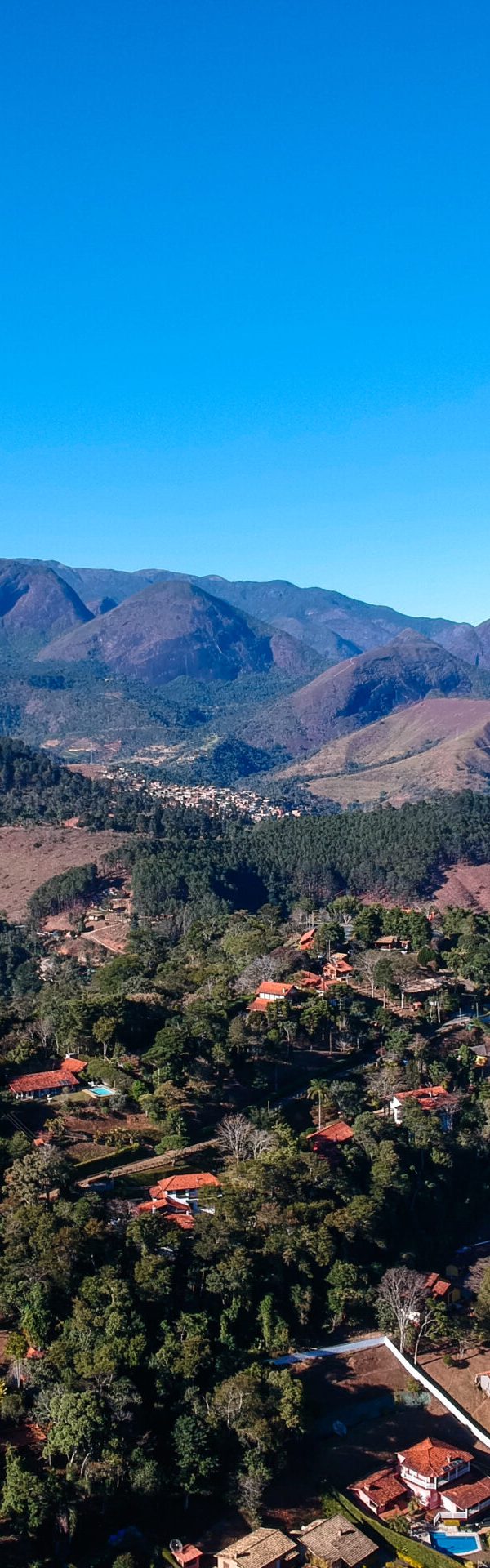 Aerial view of Itaipava, Petrópolis. Mountains with blue sky and some clouds around Petrópolis, mountainous region of Rio de Janeiro, Brazil. Drone photo. Sunny day.